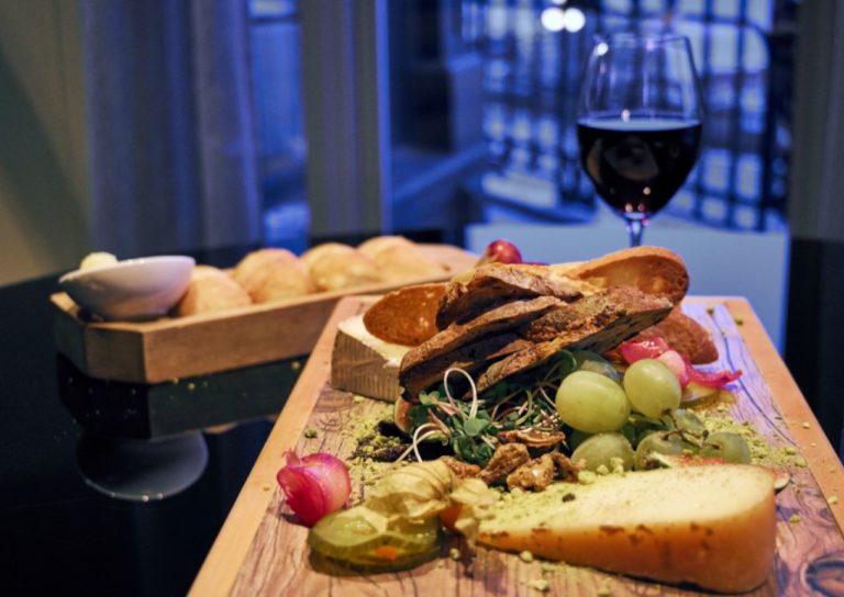 Plateau de fromages et de raisin avec un verre de vin