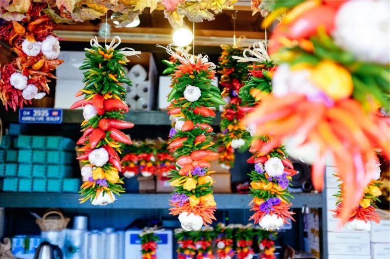 Guirlandes de piments et de légumes colorés sur un étal